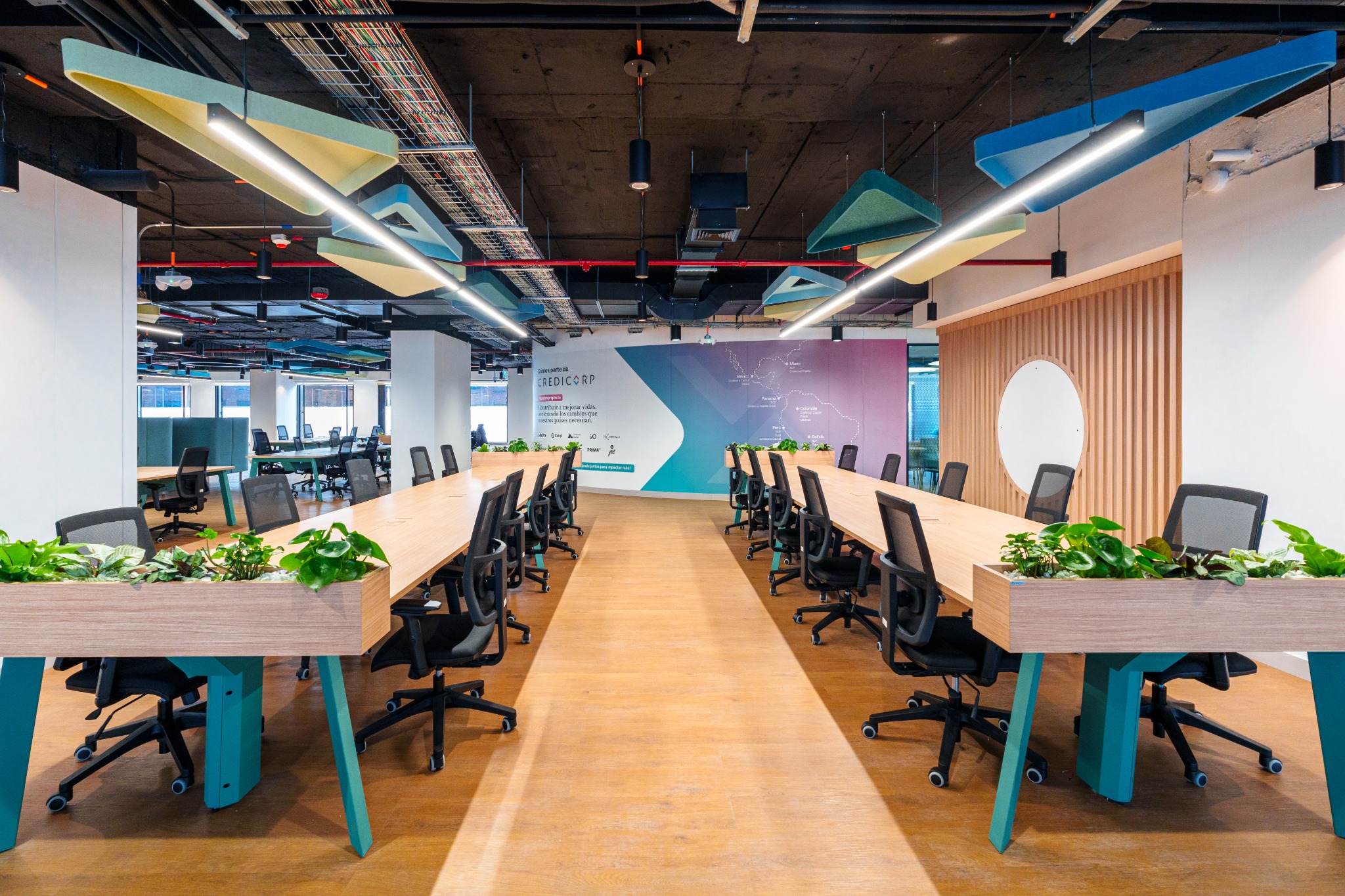 Puestos de trabajo con escritorios compartidos y sillas ergonómicas en una oficina corporativa
